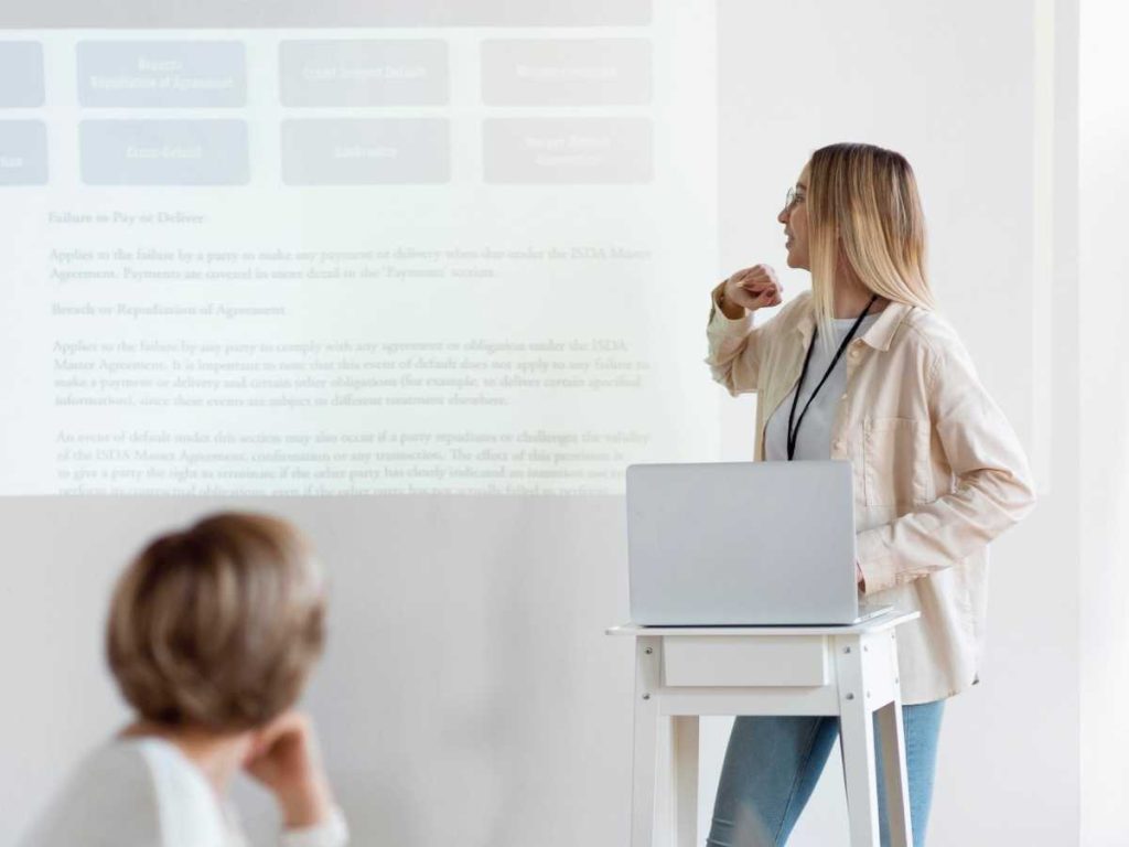 Estudiante presentando su TFG con diapositivas en una sala de conferencias