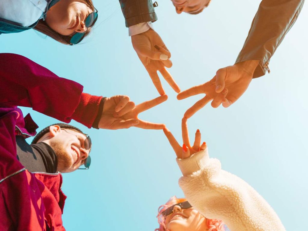 Grupo de personas uniendo sus manos en señal de colaboración y apoyo comunitario