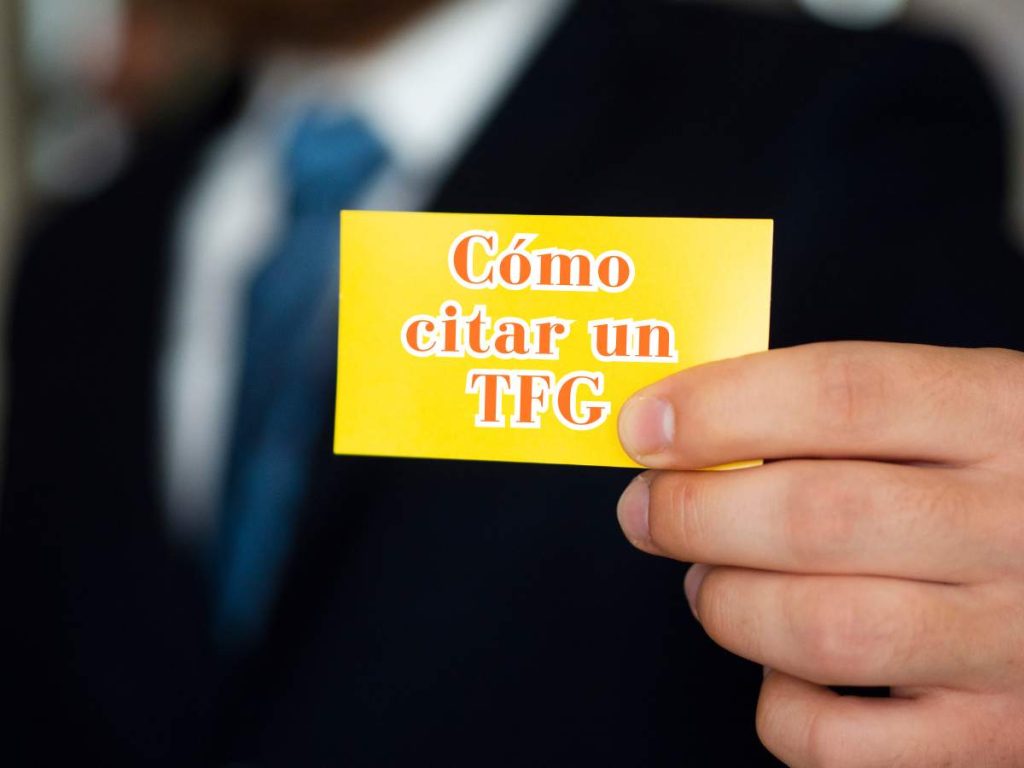 Hombre sosteniendo una tarjeta amarilla con la frase 'Cómo citar un TFG', representando la importancia de la citación correcta en trabajos académicos.