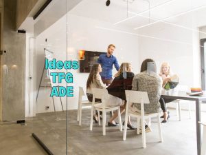 Grupo de estudiantes trabajando en un proyecto en una sala de reuniones, ilustrando brainstorming de ideas para un TFG en ADE.