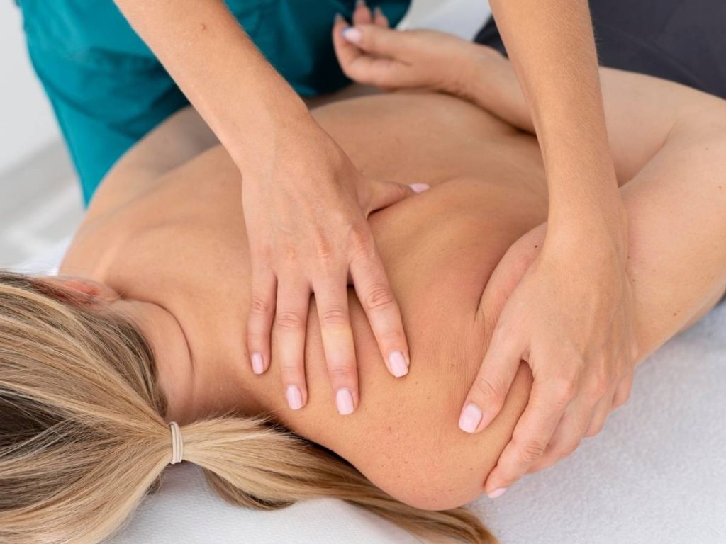 Fisioterapeuta aplicando kinesiotape en el cuello de un paciente, representando un TFG en fisioterapia.