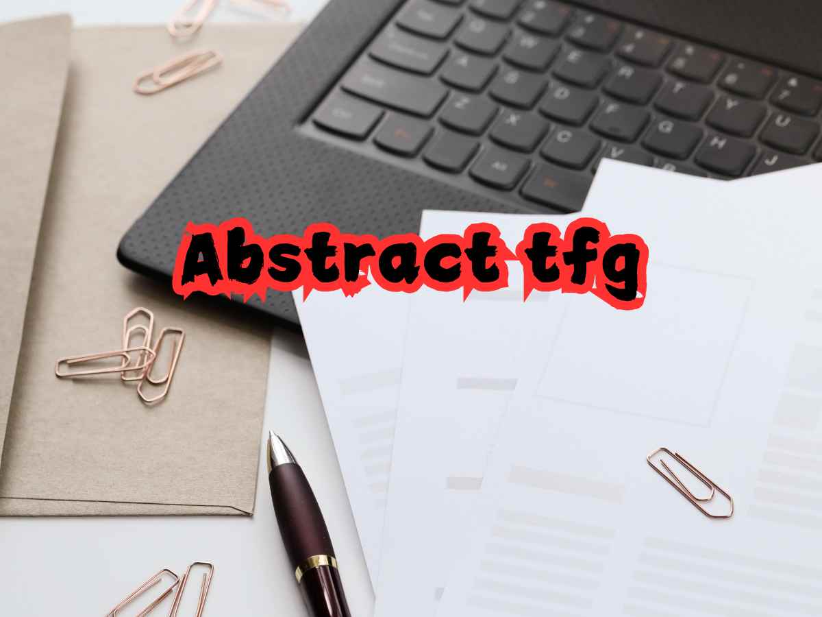 Documentos y laptop con texto 'Abstract TFG' sobre un escritorio