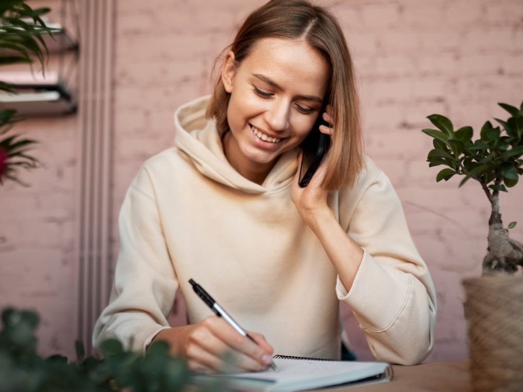 Mujer mirando un libro y llamando para recopilar información sobre un estudio de caso